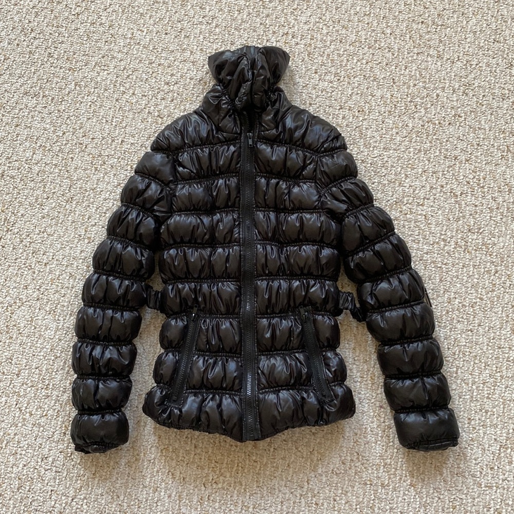 Black puffy jacket with tie in the waist and zipper pockets